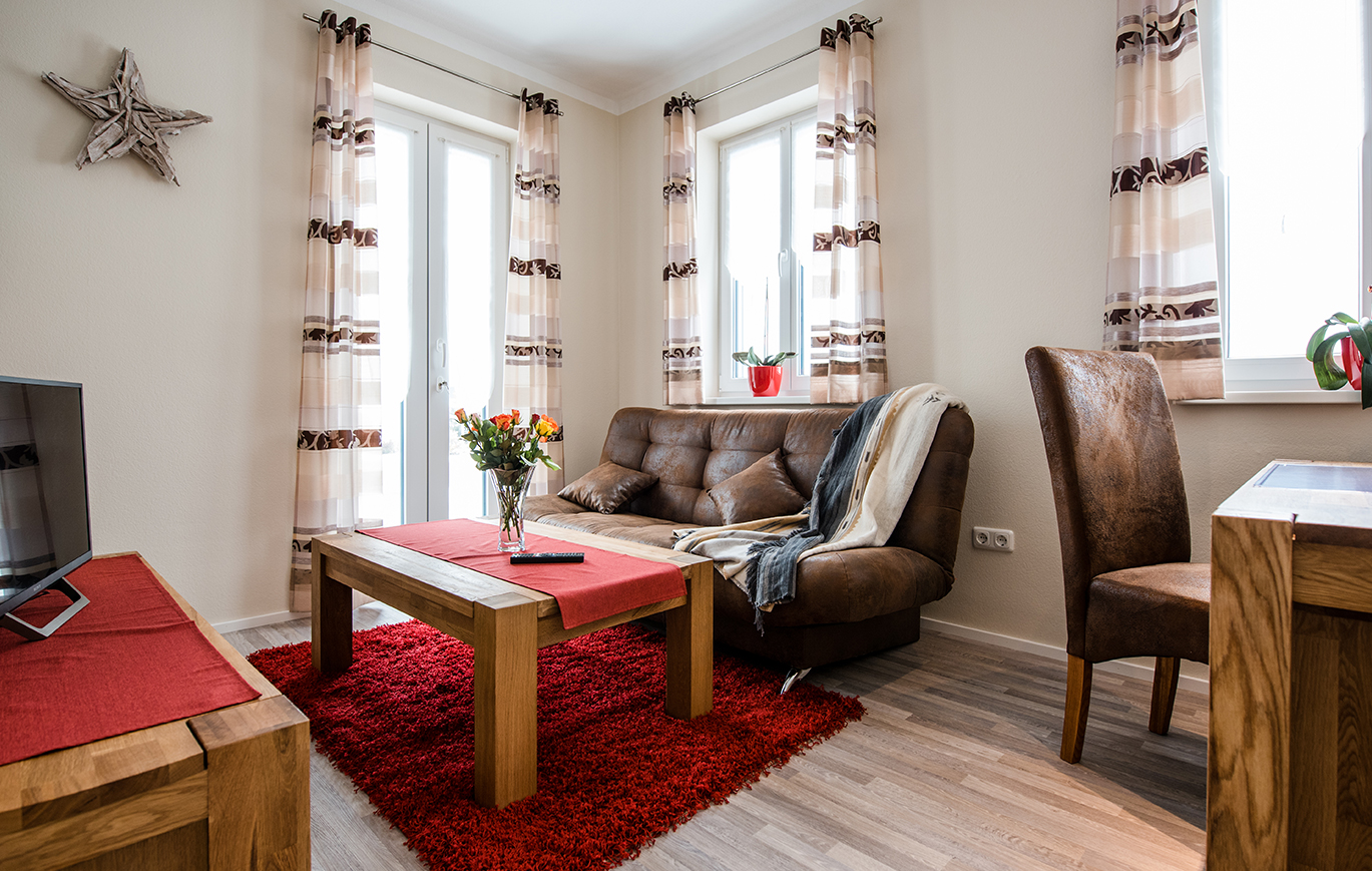 Wohnbereich mit Ledercouch im Business Apartment Franken
